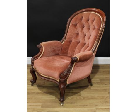 A Victorian mahogany spoon back drawing room chair, deep-buttoned upholstery, the outswept arms and cabriole legs carved with