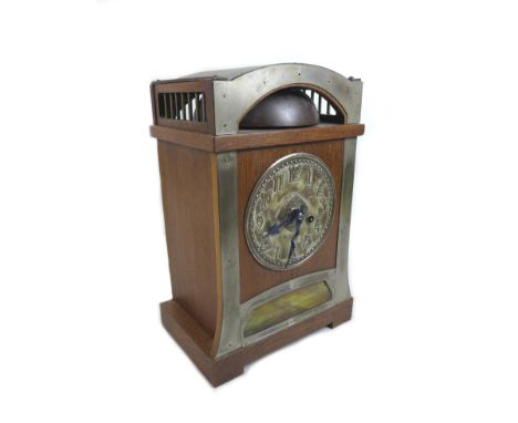 An Arts & Crafts style mantle clock, with an oak case, bell to top, pressed and hammered metal dial, twisted blued steel hand