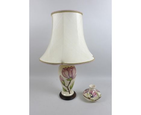 A Moorcroft pink magnolia pattern table lamp with wooden stand, lamp base only 13.5 by 29cm high and a squat form vase in the