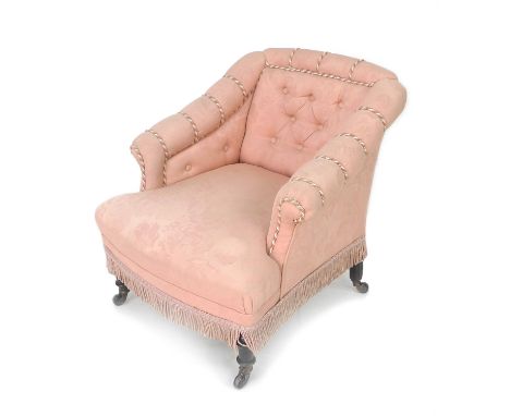 A Victorian salon armchair, with squared back and scroll over arms, upholstered in buttoned pink foliate fabric with rope twi