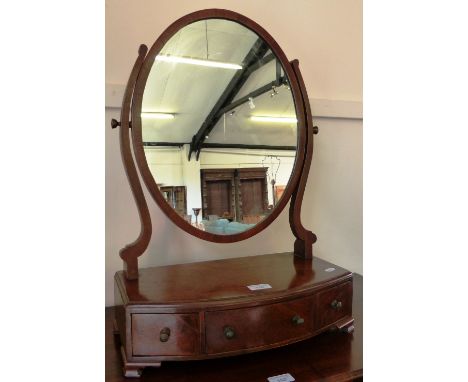 An Edwardian mahogany oval swing toilet mirror, with bow fronted three drawer base