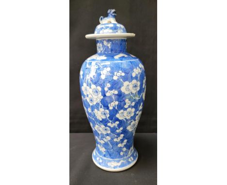 CHINESE EXPORT BALUSTER VASE AND COVERin the Kangxi style, with prunus flowers on a blue ground, the domed lid with lion fini