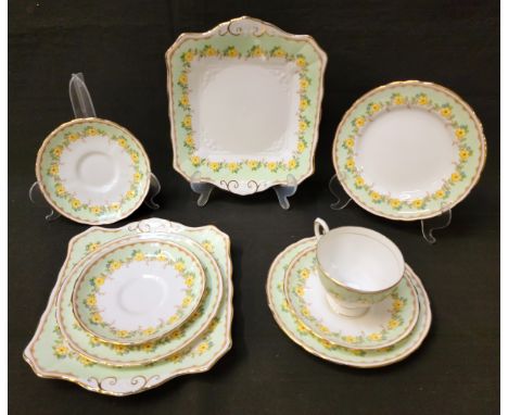 1930s TUSCAN TEA SETdecorated in green and gilt with yellow flowers, comprising two cake plates, twelve cups & saucers, twelv