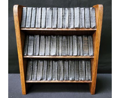 THE WORKS OF WILLIAM SHAKESPEARE comprising forty miniature leather bound volumes, displayed in a miniature oak book trough