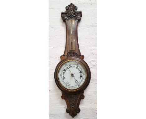 LATE VICTORIAN MAHOGANY BANJO ANEROID BAROMETERwith white enamel dial, the case with carved scroll work and foliate decoratio