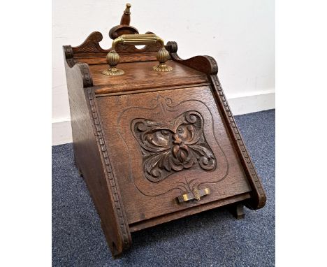 VICTORIAN OAK COAL SCUTTLEwith Green man to front, brass handle to top and with shovel and pocket to back, 38cm high