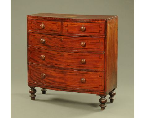 An early 19th century mahogany bowfronted chest of drawers, with wooden knob handles and geometric stringing to the drawer fr