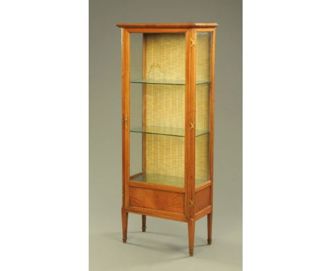 A continental oak display cabinet, with moulded edge above a glazed door flanked by moulded columns and enclosing glass shelv