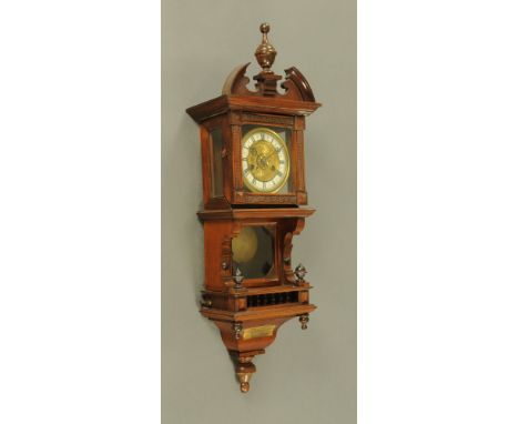 An Edwardian carved walnut wall clock, Vienna style bearing plaque dated 1911 and with two train striking movement.  Height 8
