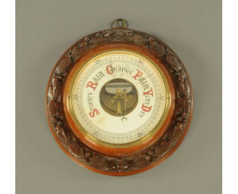 An early 20th century circular carved oak barometer, with aneroid movement.  Diameter 31 cm. CONDITION REPORT: The barometer 