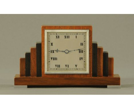 An Art Deco walnut and ebonised mantle clock, square dial with Roman numerals and with French made single train movement.  He
