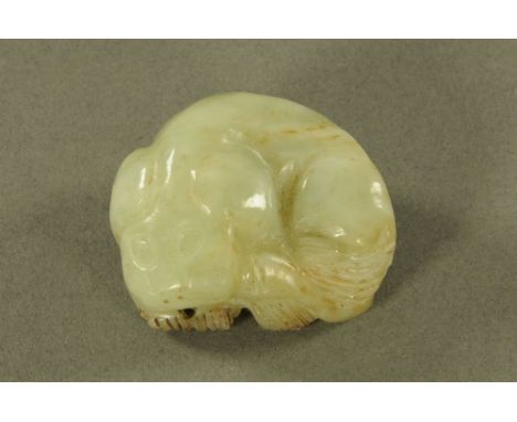 A jade Netsuke depicting a sleeping Dog of Fo. Length 44 mm.