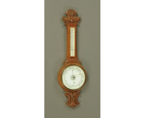A carved oak banjo barometer, circa 1930 with ceramic dial and mercury thermometer.  Height 84 cm.