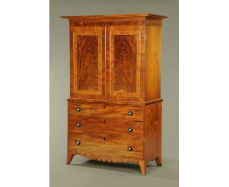 A George III mahogany linen press, with moulded cornice above a pair of well figured panelled doors, crossbanded and opening 