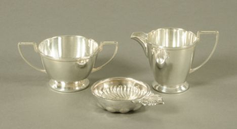 A silver plated sugar basin and cream jug, together with French silver coloured metal tastevin.