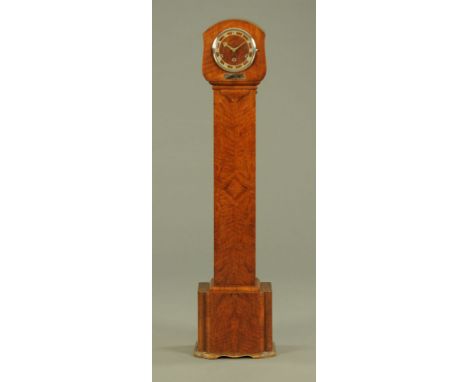 An Art Deco walnut cased grandmother clock, with three train striking movement with circular dial.  Height 145 cm.