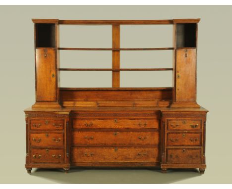 A large 18th century oak dresser with Delft rack, the rack with shelves, cupboards and spice drawers, the base with inverted 