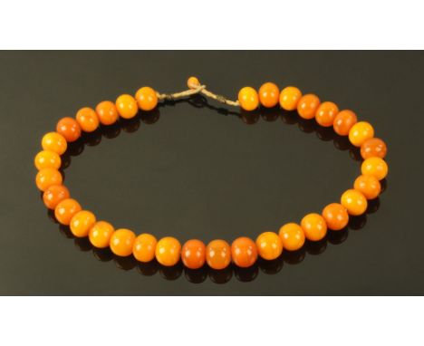 A vintage butterscotch amber necklace, gross weight 40 grams. CONDITION REPORT: The beads vary from 9 mm to 11 mm in diameter