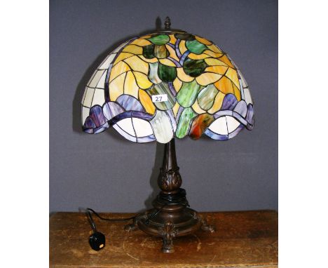 A Tiffany style lamp, the multicoloured shade of circular form standing on a bronzed effect stylized base, the shade of large