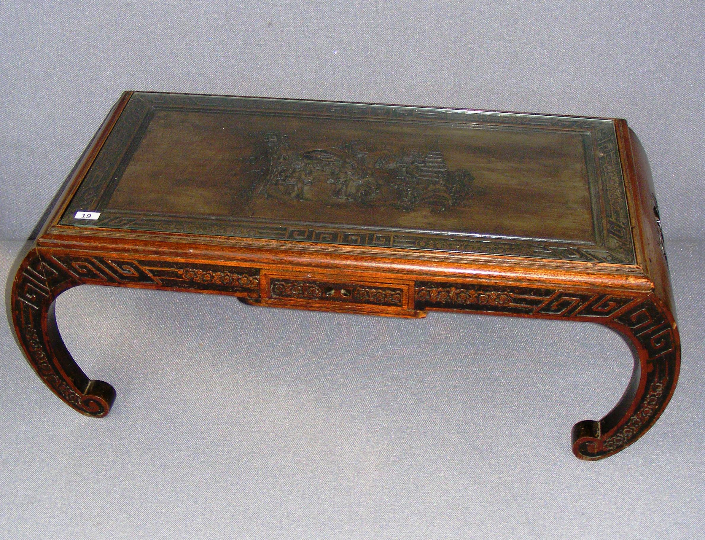 A early to mid 20th century Chinese coffee table, profusely carved with figures and decoration, o