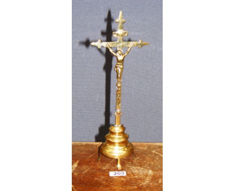 A late 18th century / early 19th century brass Corpus Crucifix, on a turned brass base standing on tripod legs.