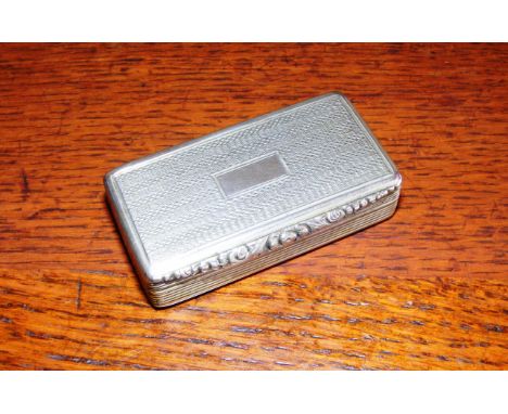 A white metal snuff box, with a gilt interior and hallmarks, engine turned decoration on the outside, with a vacant cartouche