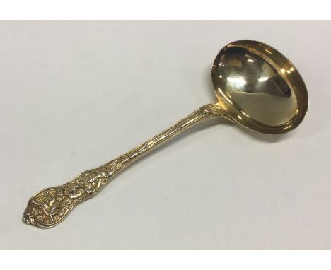 A fine quality silver gilt sauce ladle with chased scene to handle. Approx. 77 grams. Est. £100 - £120.