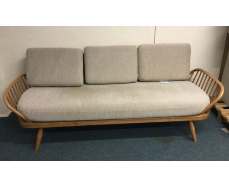 ERCOL: A large three seater day bed. Est. £100 - £200.