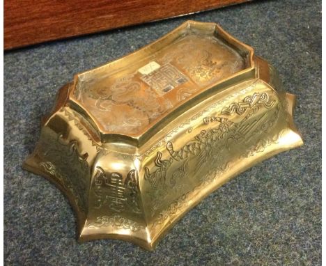 A heavy shaped brass Chinese bowl decorated with winged animals. Seal mark to base. Est. £30 - £50.
