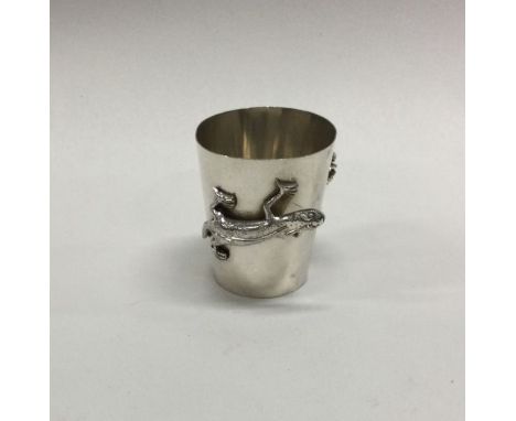 A Chinese chased silver tot decorated with a lizard and a spider. Approx. 16 grams. Est. £60 - £80.