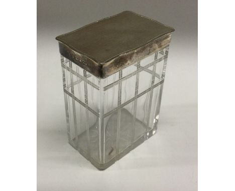 A large silver and glass engine turned toilet box. London 1914. By Mappin and Webb. Est. £30 - £40.