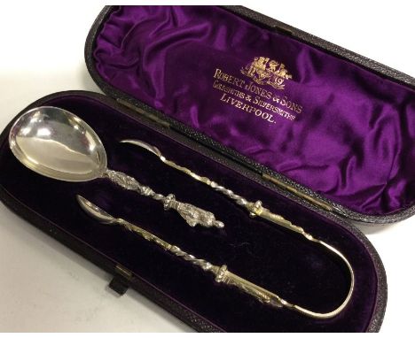 A Victorian cased caddy spoon and tongs with Apostle decoration. London 1880. By Charles Edwards. Approx. 52 grams. Est. £70 