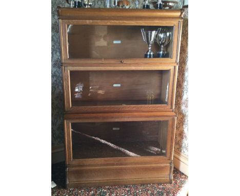 A three section oak Globe Wernicke bookcase. Est. £200 - £300.