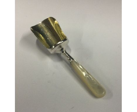 A silver shovel shaped caddy spoon with MOP handle. Birmingham 1810. By William Pugh. Approx. 9 grams. Est. £60 - £80.