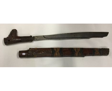 A good Antique tribal knife with carved handle and matching scabbard. Est. £100 - £150.