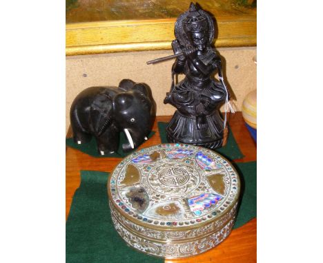 A carved hardwood Eastern deity figure, wooden elephant and brass and enamel box