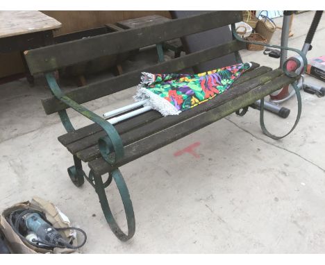 A WOODEN BENCH WITH CAST IRON ENDS AND A PARASOL 