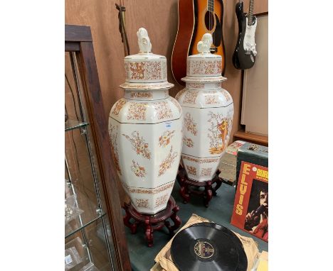 A PAIR OF LARGE CERAMIC VASES ON WOODEN BASES 