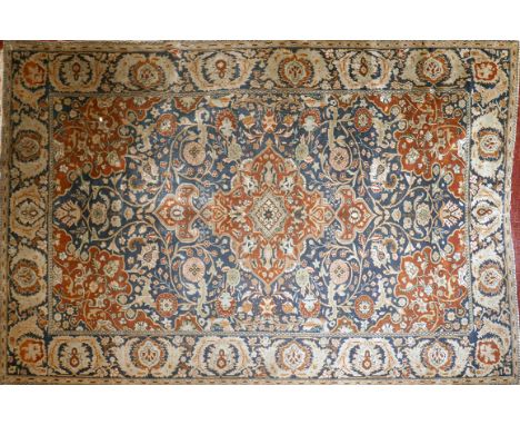 An antique Turkish Hereke rug, the central ruby medallion on a midnight blue ground with Kashan style palmette and vine decor