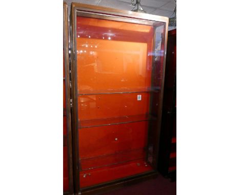 An early 20th Century walnut and bronze display case with fitted glass shelves and red baize interior, H.217cm W.112cm D.32cm