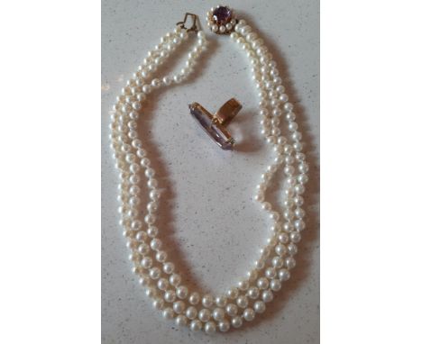A 9ct gold contemporary ring having a large oval faceted amethyst cabochon together with a multi-string simulated pearl neckl