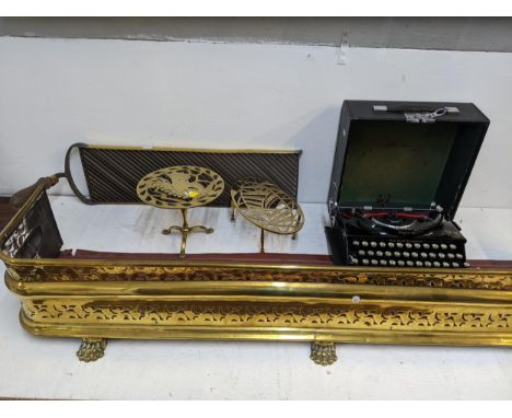 An Imperial typewriter, a brass fire curb, two trivets and a whey cutterLocation: 
