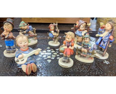 Eight Goebel figures to include Apple Tree girl, School girl, Hear Ye Hear Ye, also a child playing a guitar and others Locat