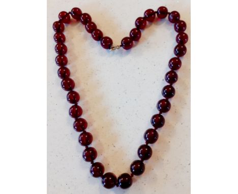 A vintage necklace of 37 cherry amber beads on string having a 9ct gold clasp. Location:Cab 