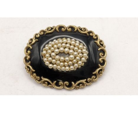 A 19th century mourning black enamel mourning brooch, set with seed pearl and a scroll work frameLocation: CAB1 