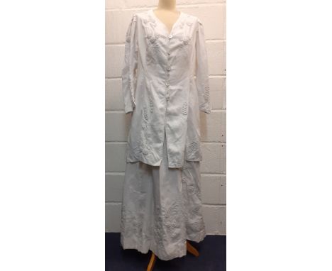 A late 19th/ early 20th Century white cotton and embroidered driving outfit comprising a longline coat and matching full leng