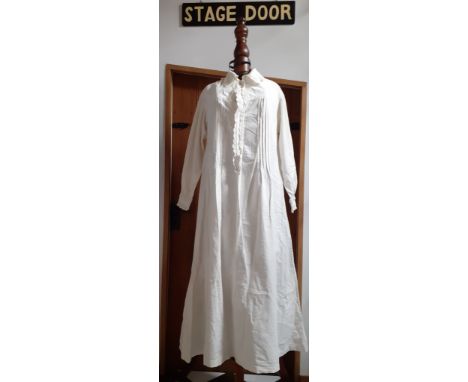 A late Victorian white cotton nightgown having crotchet trim to the collar, front closure and cuffs with 4 fabric covered fro