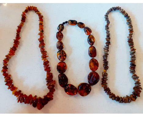A vintage amber necklace having 15 beads of various sizes and shapes together with 2 vintage rough-cut amber necklaces. Locat