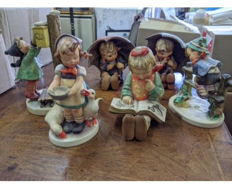 Six Goebel figures to include a girl and boy both sitting under umbrellas, a boy posting a letter, a child on a fence and a g