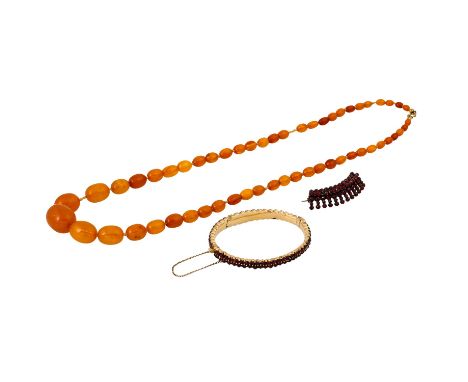 3-teiliges Schmuckkonvolut best. aus 1 Pressbernsteinkette, 1 Armreif und 1 Brosche mit Granaten, unedles Metall, Tragespuren